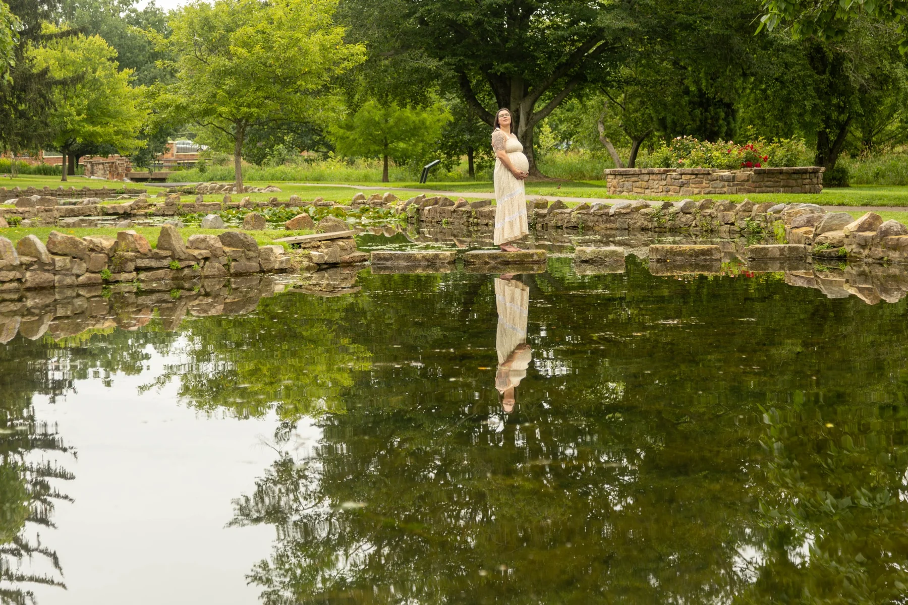 Maternity portrait reflected in a garden pond